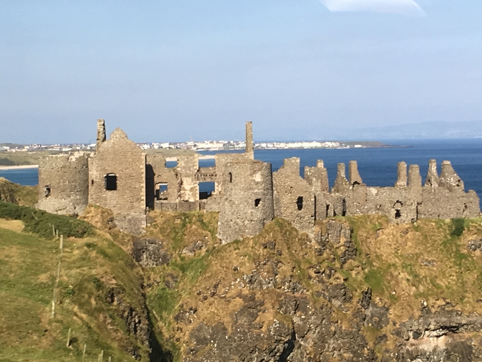 Château en ruine sur une falaise surplombant la mer.