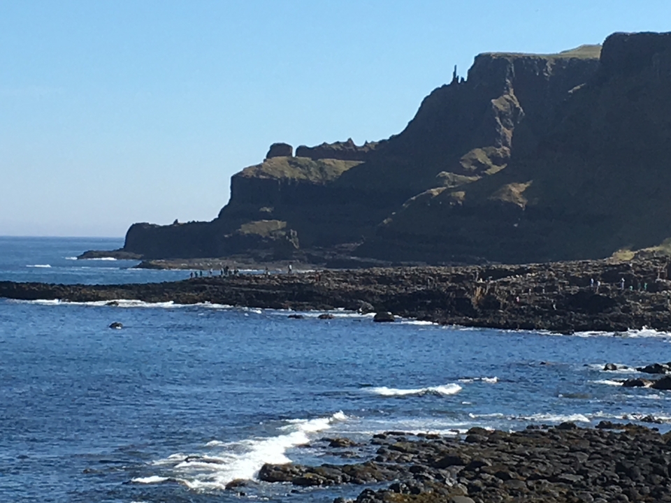 Une côte rocheuse avec un ciel bleu clair.
