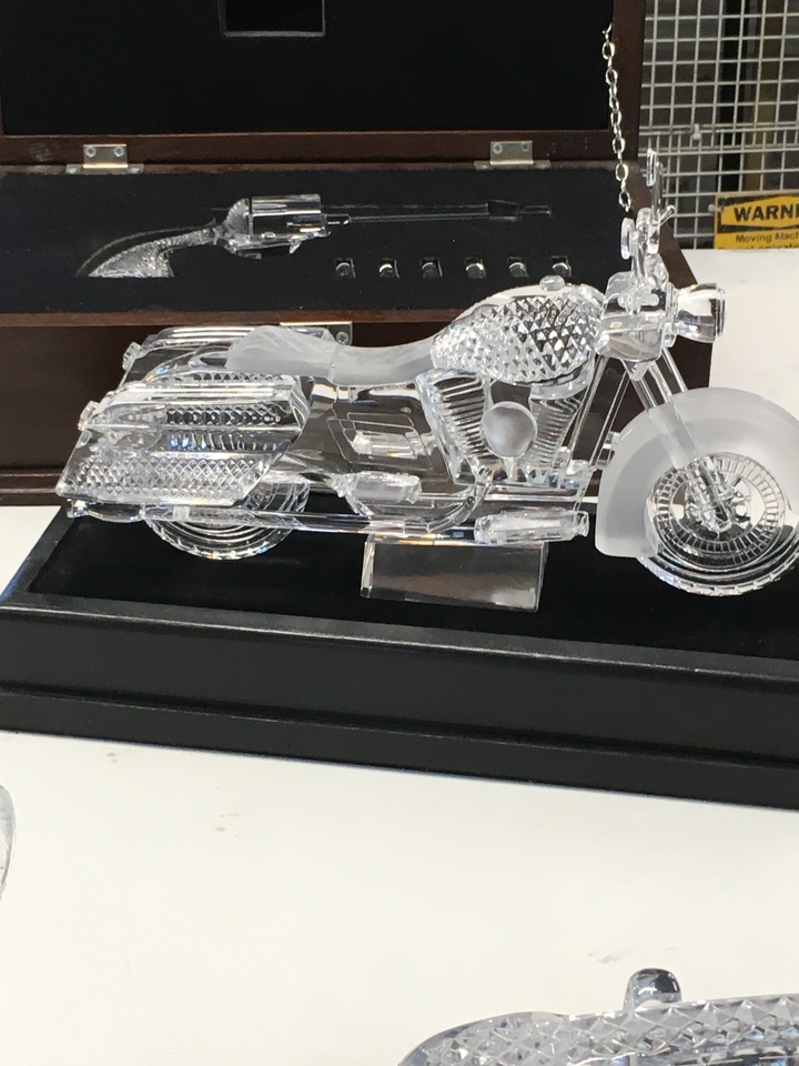 A glass sculpture of a motorcycle on display.