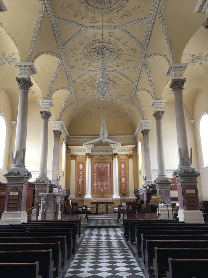 Intérieur d'église élégant avec lustres et colonnes.