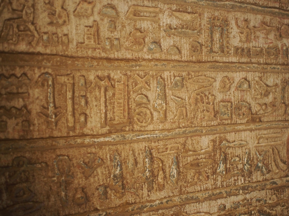 Gros plan d'anciens hiéroglyphes sur une surface en pierre.