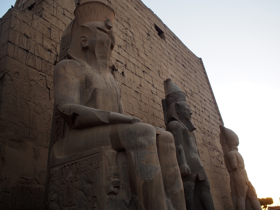 Vue latérale de grandes statues à l'entrée d'un temple.