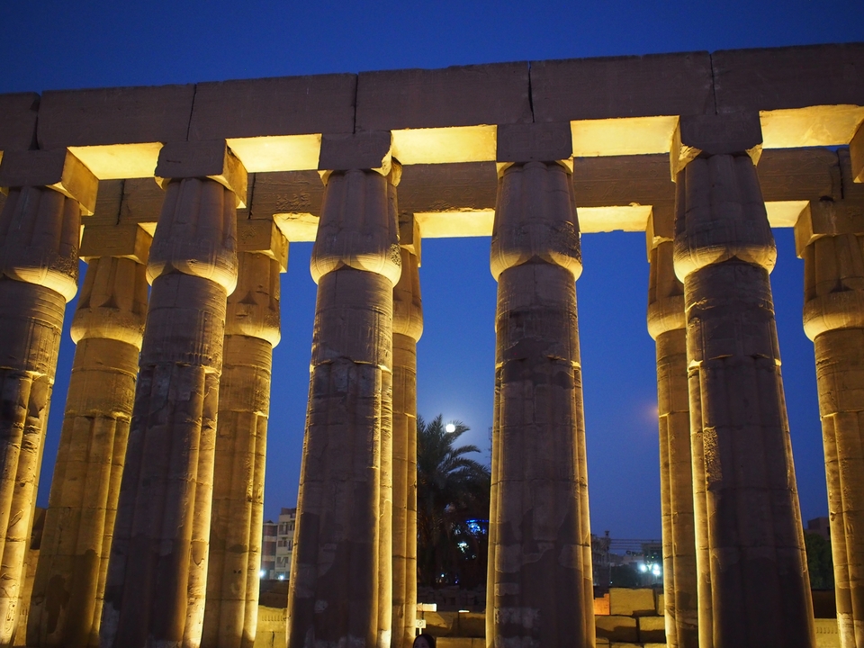 Colonnes illuminées d'un temple antique au crépuscule.