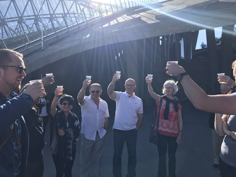 Groupe fêtant avec des boissons dans un cadre extérieur.