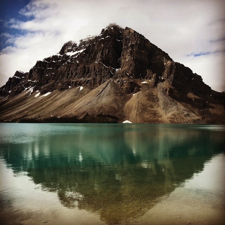 Paysage de montagne avec un lac turquoise réfléchissant.