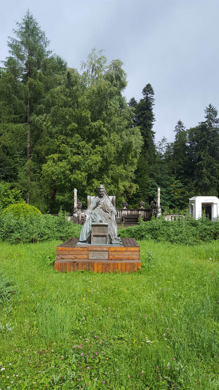 Statue dans un parc entouré de verdure.