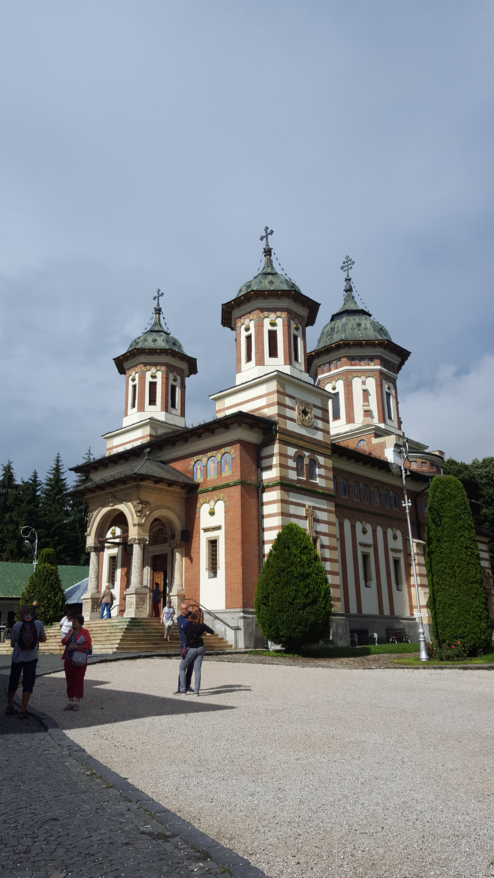 Église historique avec une façade en briques rouges et blanches et des toits en dôme.
