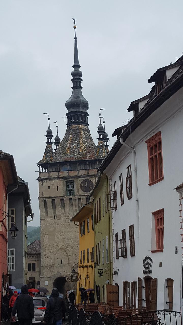 Tour d'horloge historique entourée de bâtiments colorés.