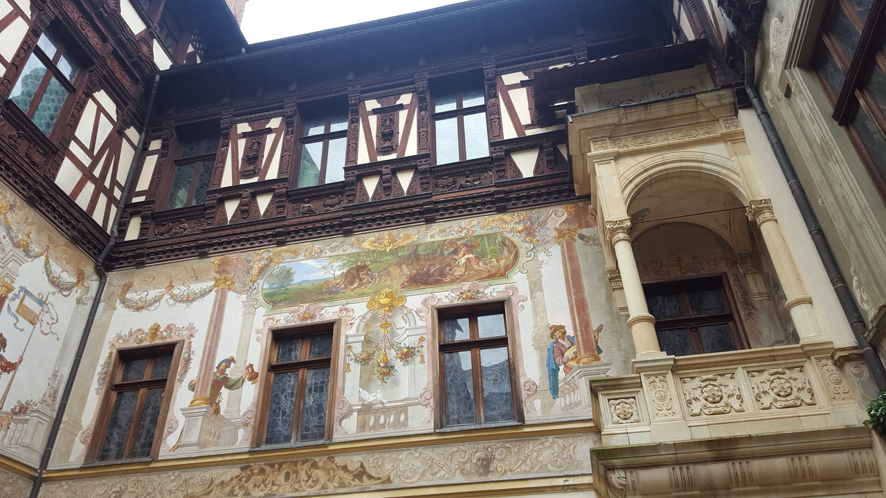 Façade d'un bâtiment historique décorée de peintures murales.