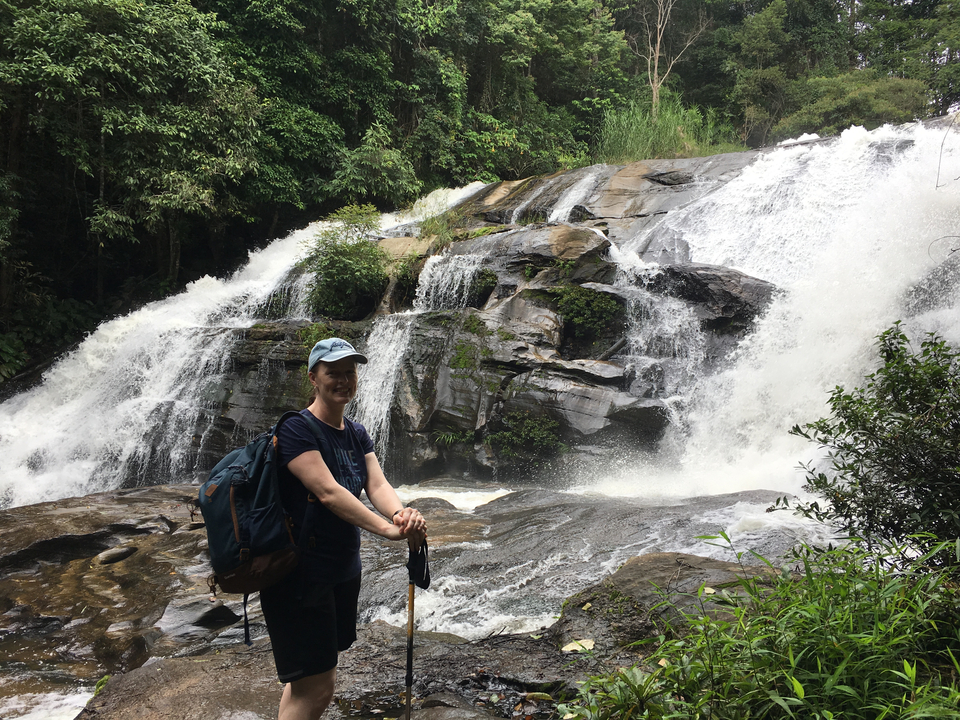 Personne debout devant une cascade.