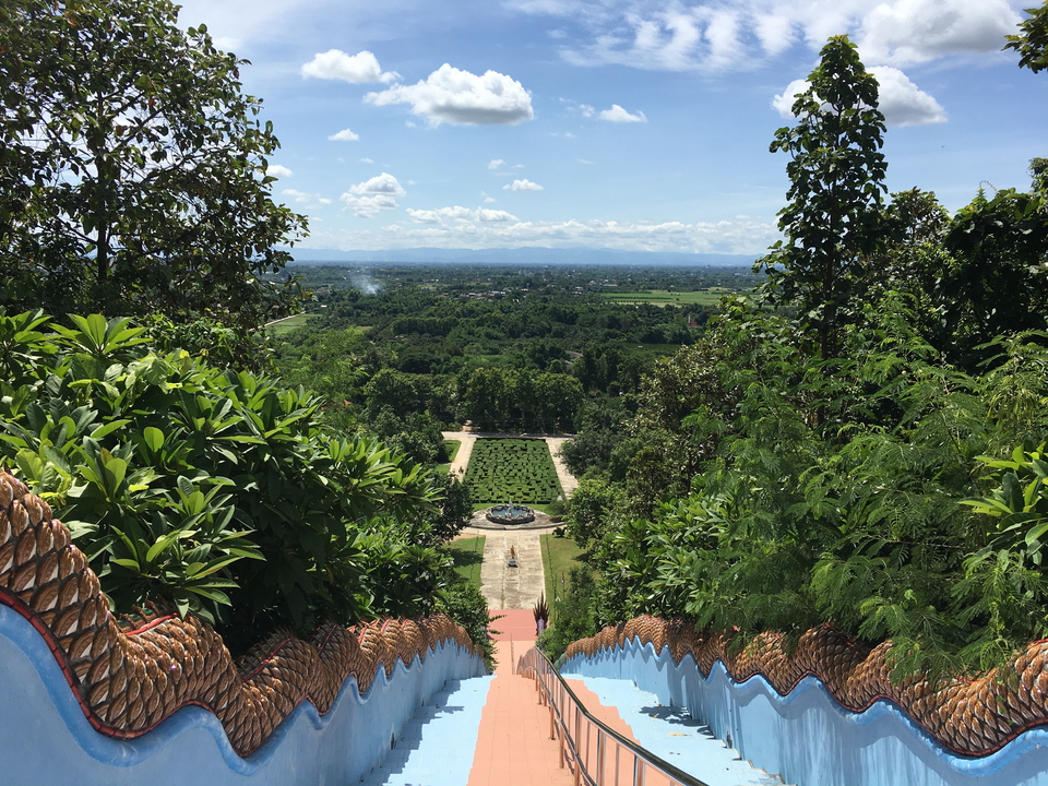 Vue d'un temple sur une verdure luxuriante et un paysage.
