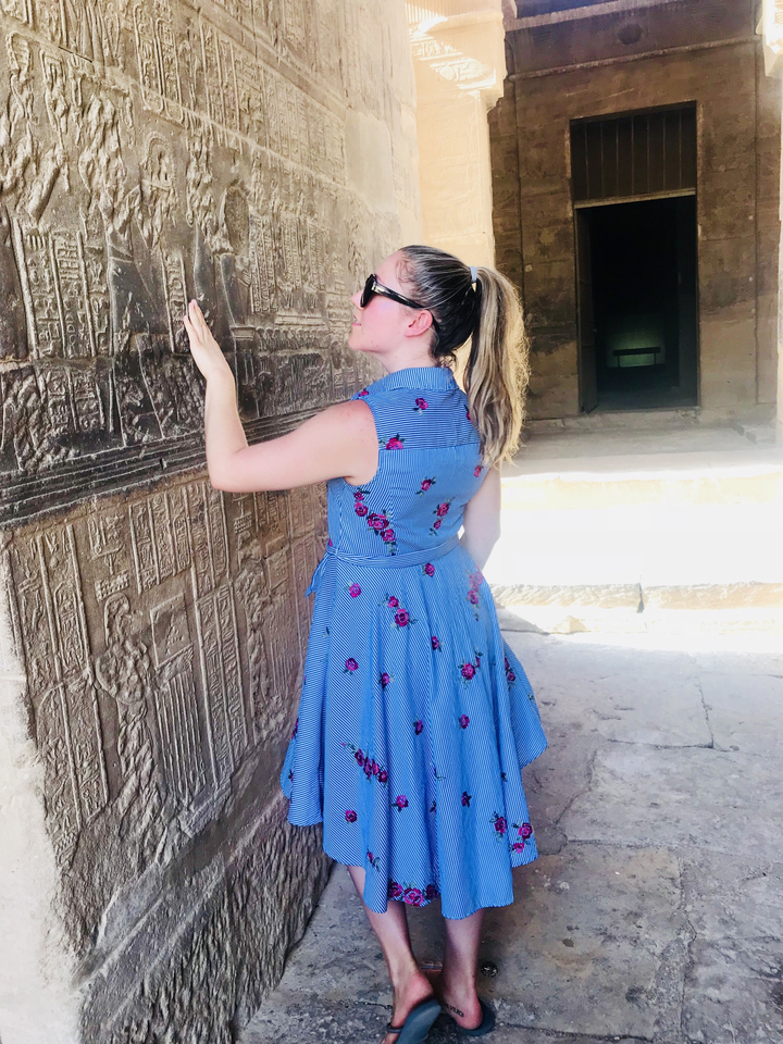 Personne touchant des gravures murales anciennes.