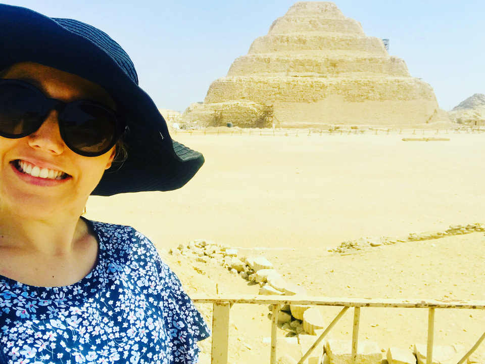 Personne avec des lunettes de soleil devant une pyramide à degrés.