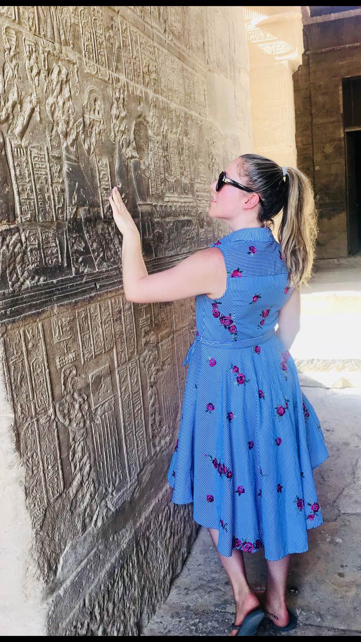 Personne touchant des gravures murales anciennes.