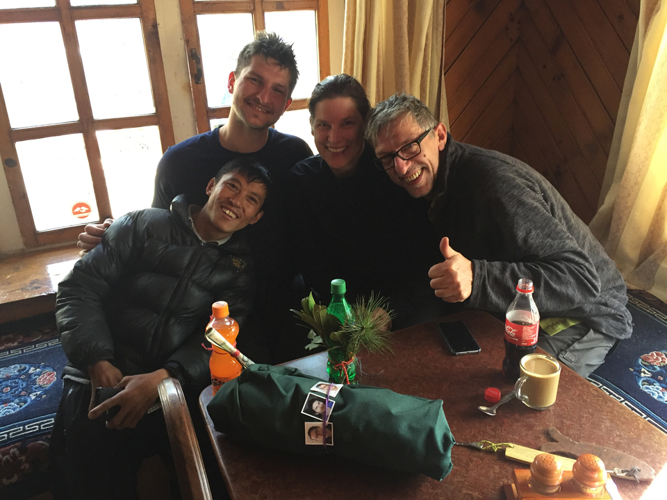 Quatre personnes assises à une table à l'intérieur avec des boissons.