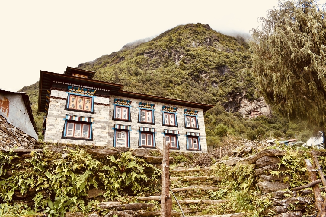 Bâtiment traditionnel avec des fenêtres colorées dans un cadre montagneux.