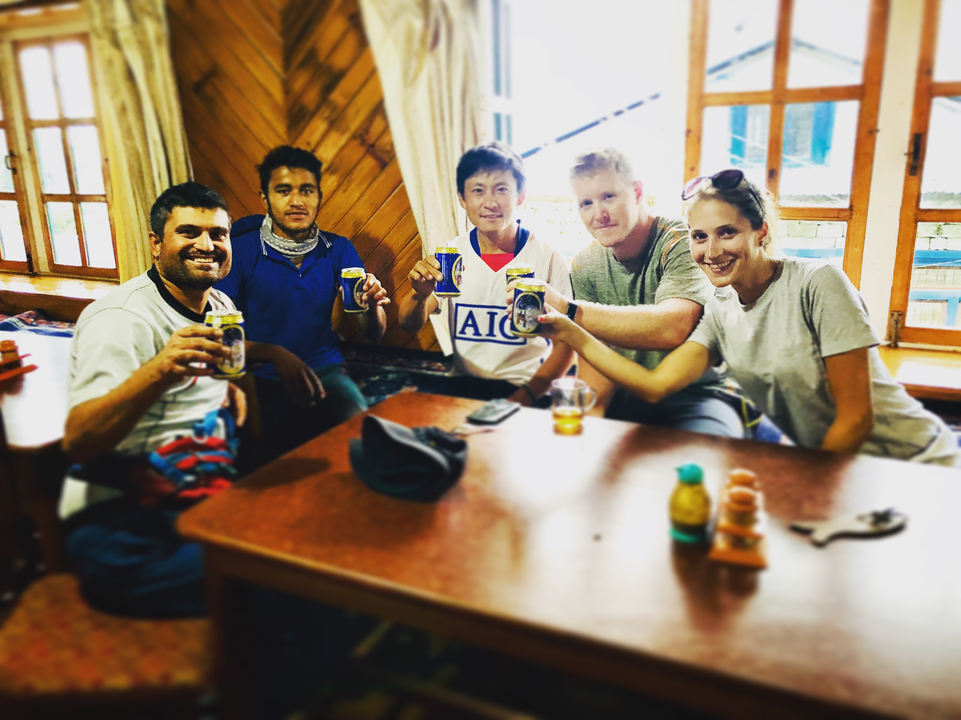 Groupe d'amis tenant des boissons dans une pièce chaleureuse.