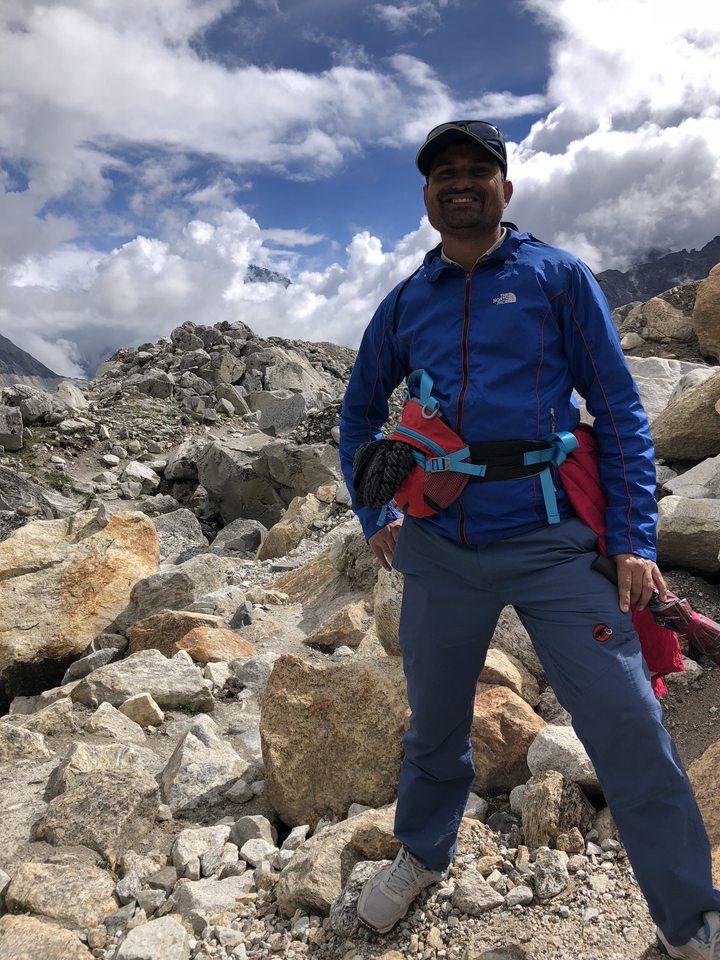 Personne en équipement de randonnée debout au milieu des rochers.