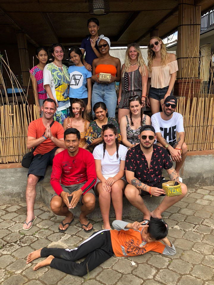 Groupe de personnes assises et souriantes à l'extérieur.