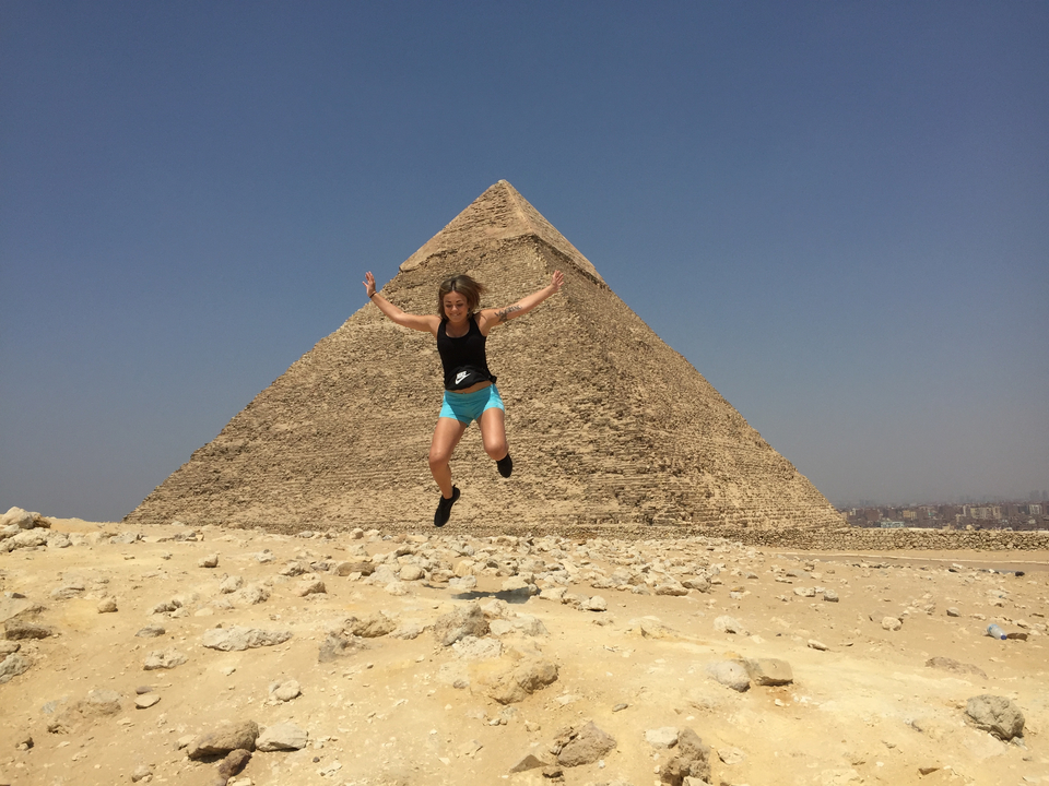 Personne sautant devant la Grande Pyramide de Gizeh.