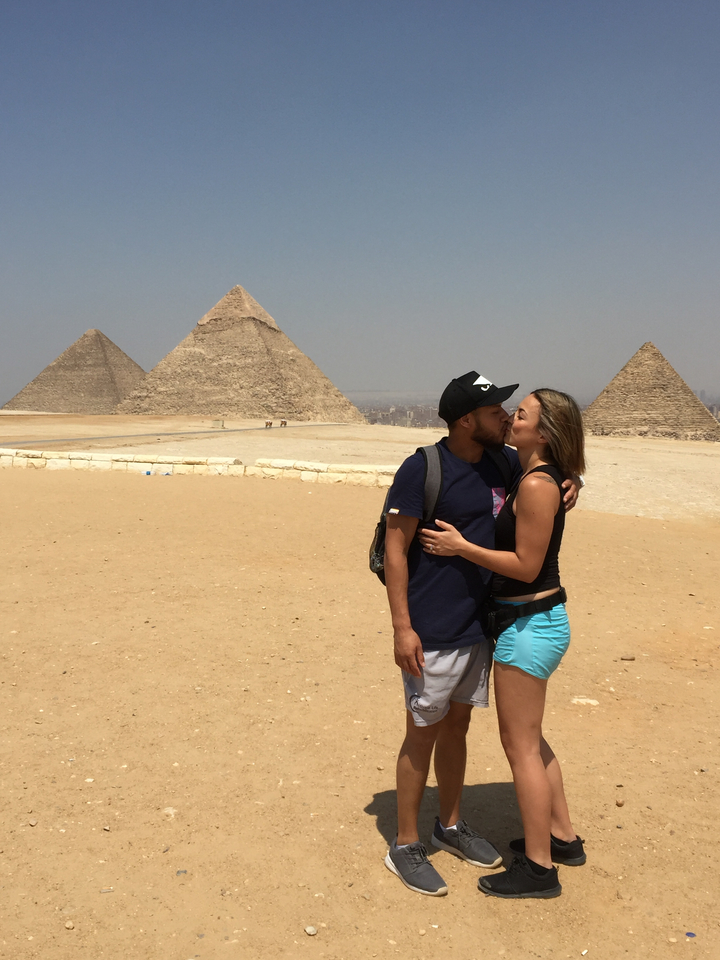 Couple s'embrassant devant les pyramides de Gizeh.