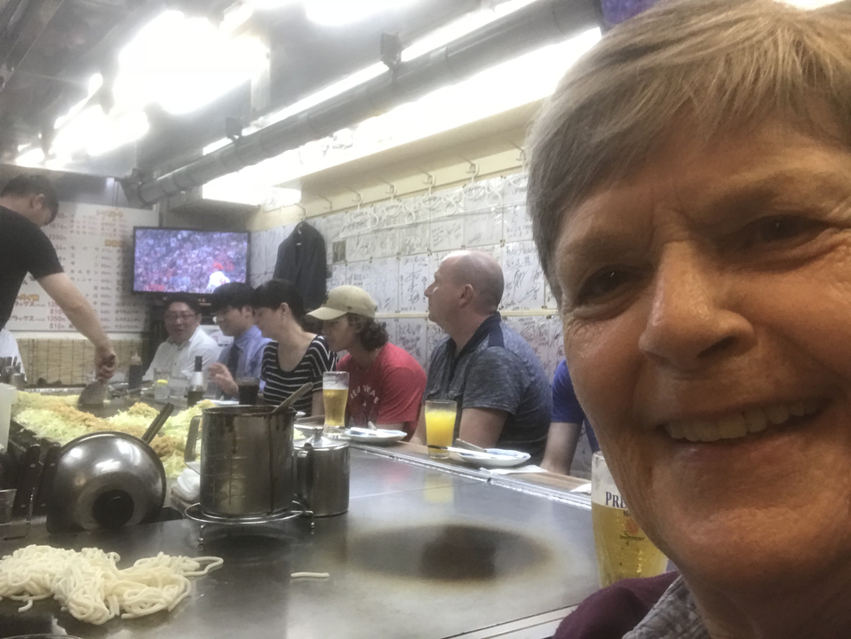 Des personnes qui dînent à l'intérieur d'un restaurant avec un menu visible au mur.