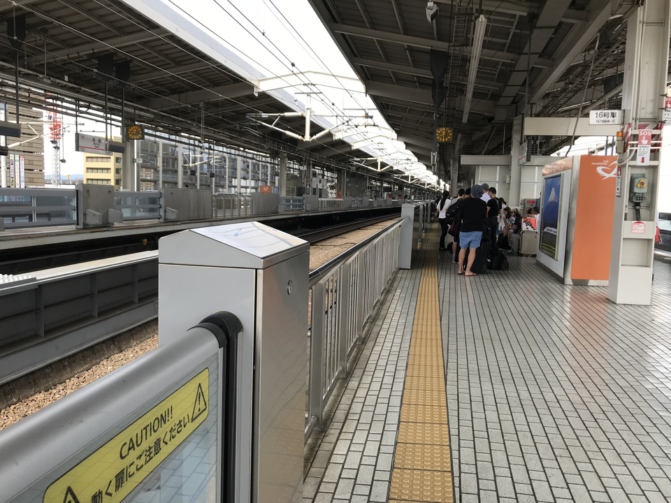 Personnes attendant sur le quai d'une gare.