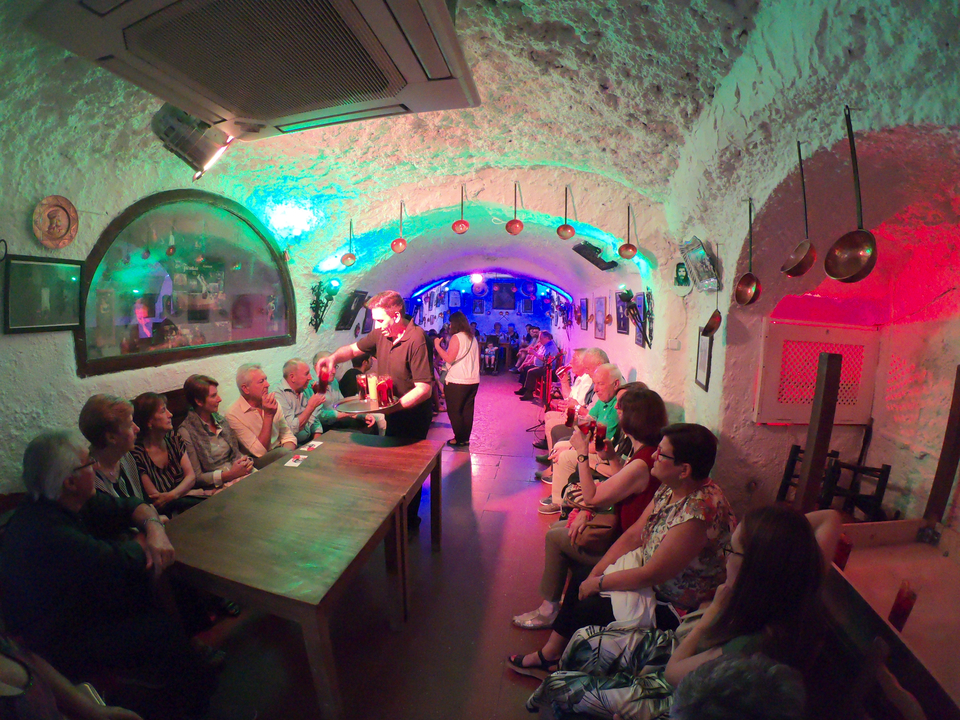 Des gens qui profitent d'un spectacle dans un lieu ressemblant à une grotte.