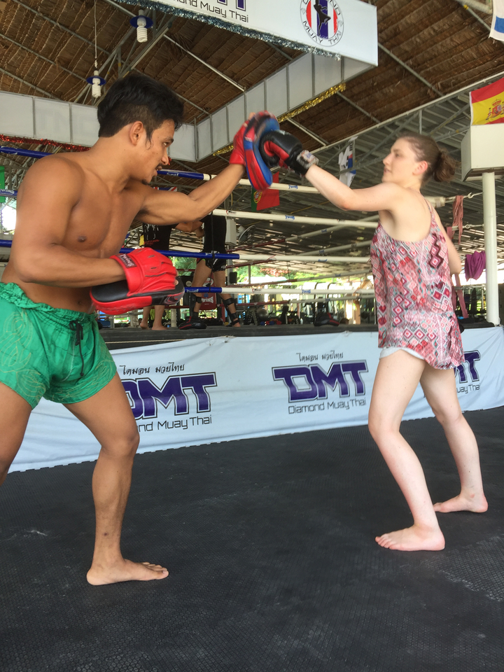 Two people sparring in a Muay Thai boxing ring