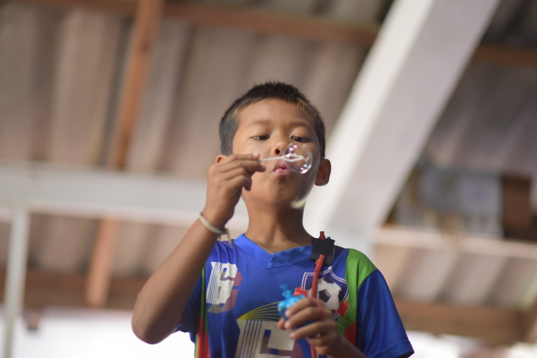 Enfant qui fait des bulles à l'intérieur.