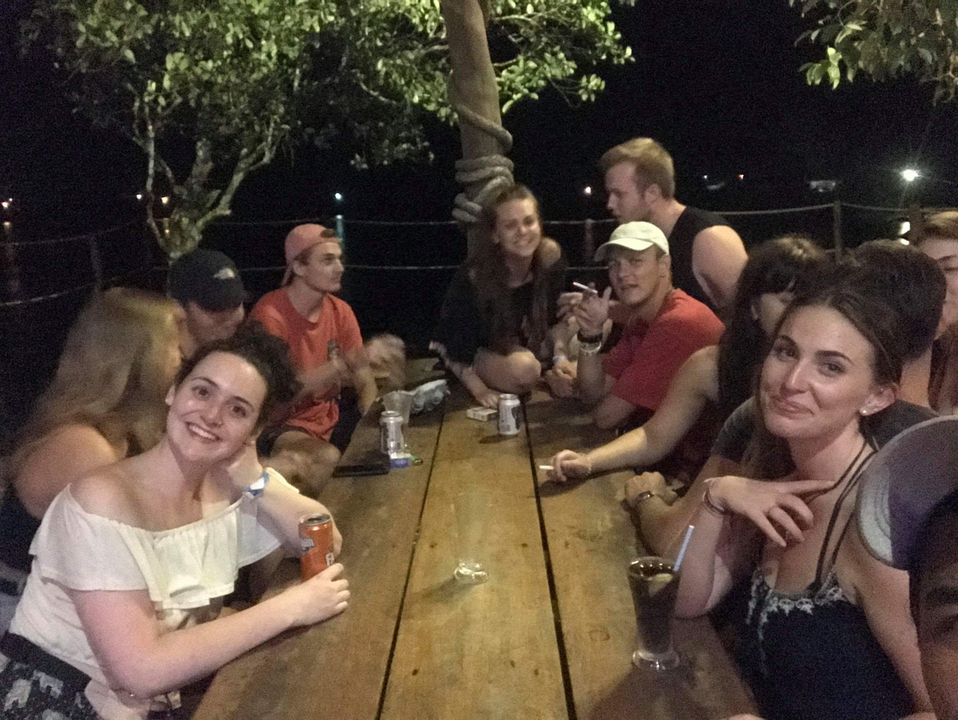 Groupe de personnes assises autour d'une table la nuit