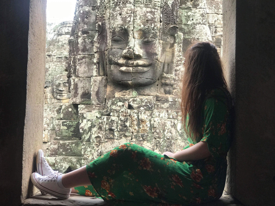 Femme regardant des sculptures en pierre dans un temple