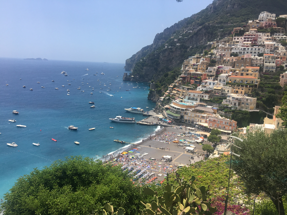 Vue de Positano avec des bâtiments colorés et des bateaux.