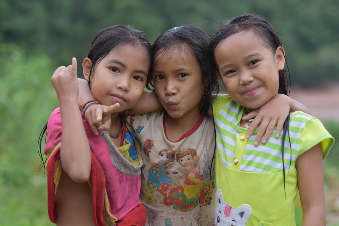 Three girls posing for a playful photo.