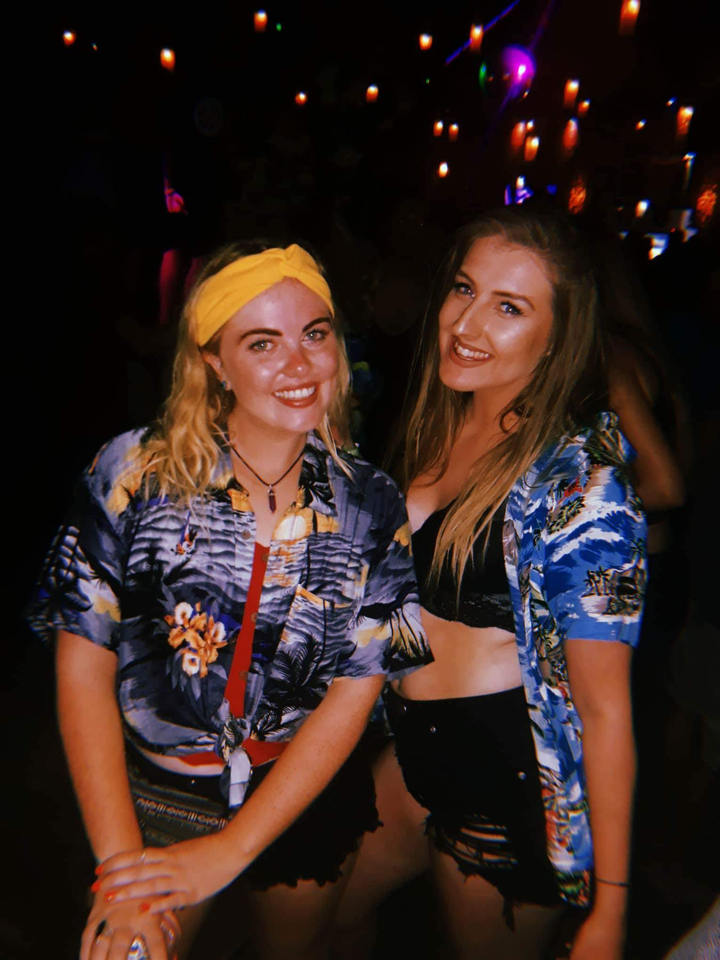 Two women posing at a night event.