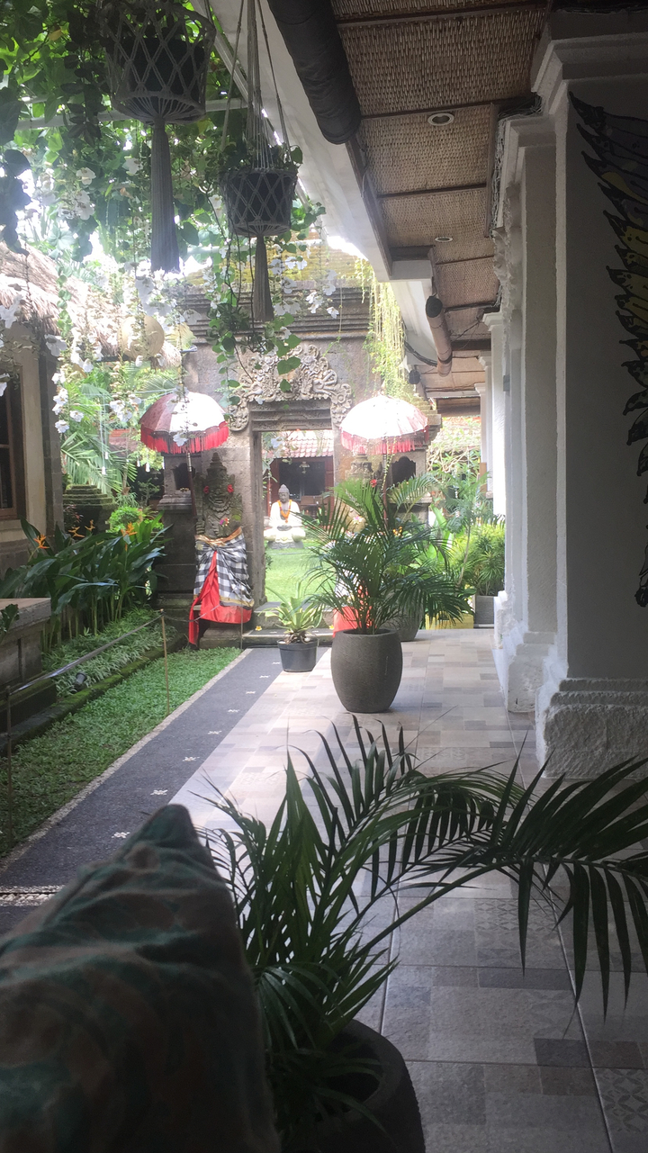 Architecture traditionnelle dans un cadre de jardin encadré par des plantes tropicales.