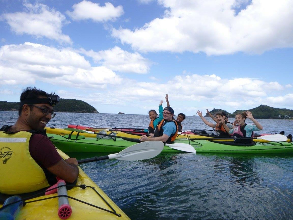 Groupe de personnes faisant du kayak sur la mer avec des visages souriants.