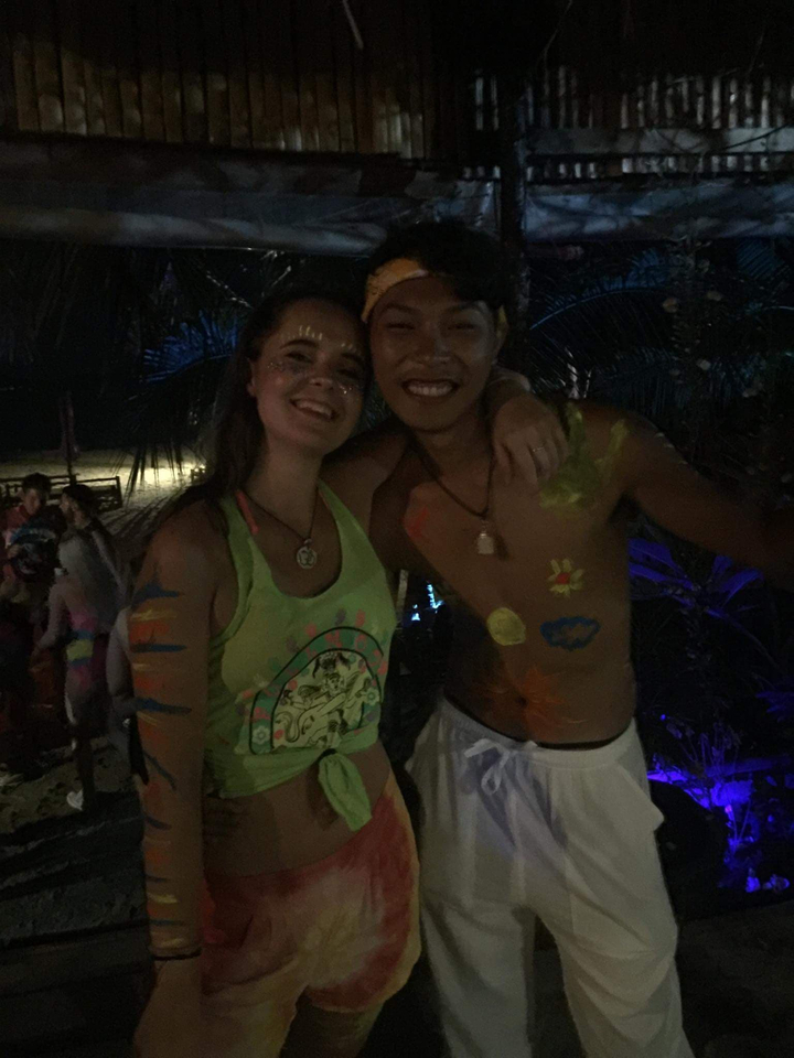 Deux personnes souriantes avec de la peinture néon sur leurs corps.