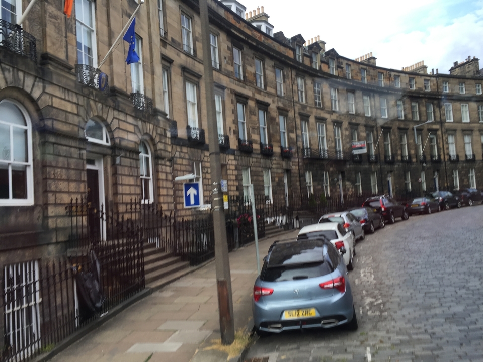 Une image floue de mouvement d'une rue de ville avec des voitures garées.