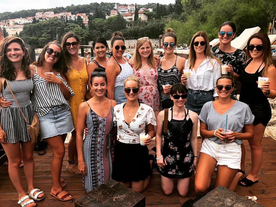 Un groupe de personnes posant ensemble avec des boissons dans un lieu de plage.