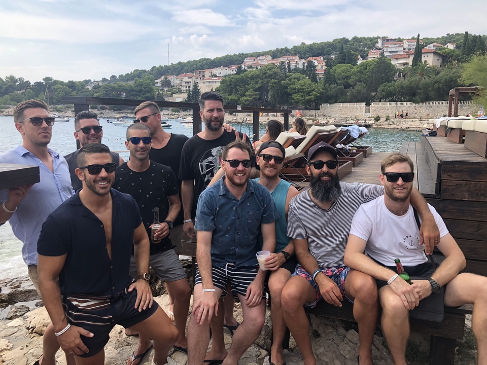 Un groupe d'hommes posant ensemble dans un club de plage.