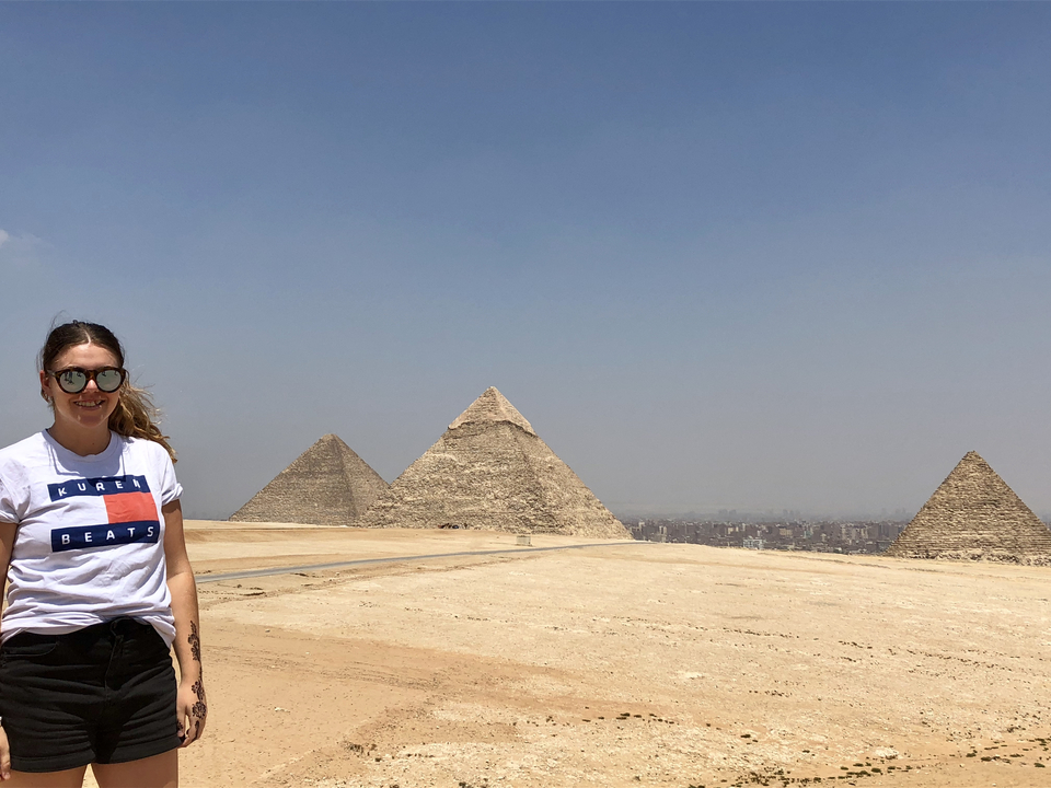Touriste aux pyramides de Gizeh avec vue sur la ville en arrière-plan.