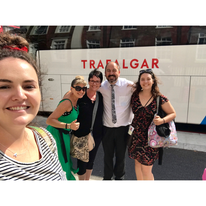 Groupe de personnes posant devant un bus marqué Trafalgar.