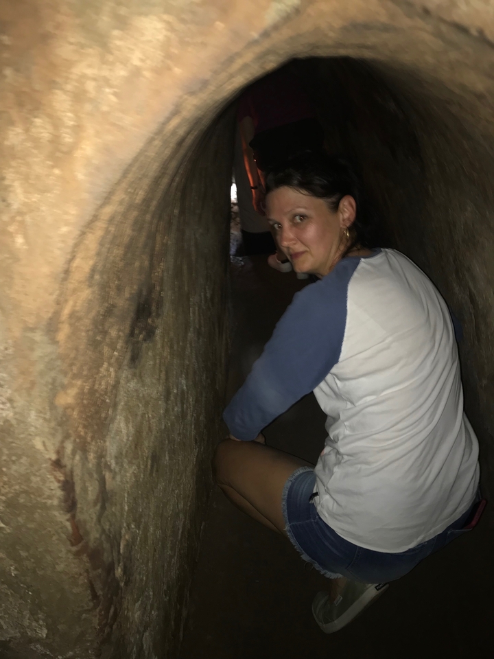 Personne rampant à travers un tunnel souterrain étroit.