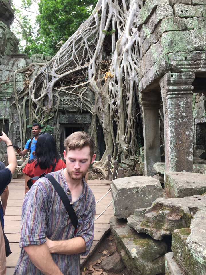 Touristes explorant de grands arbres et des structures anciennes.