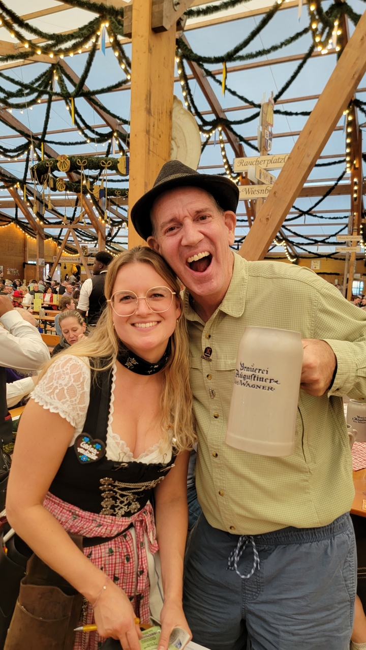 Deux personnes en vêtements traditionnels tenant une grande chope de bière.