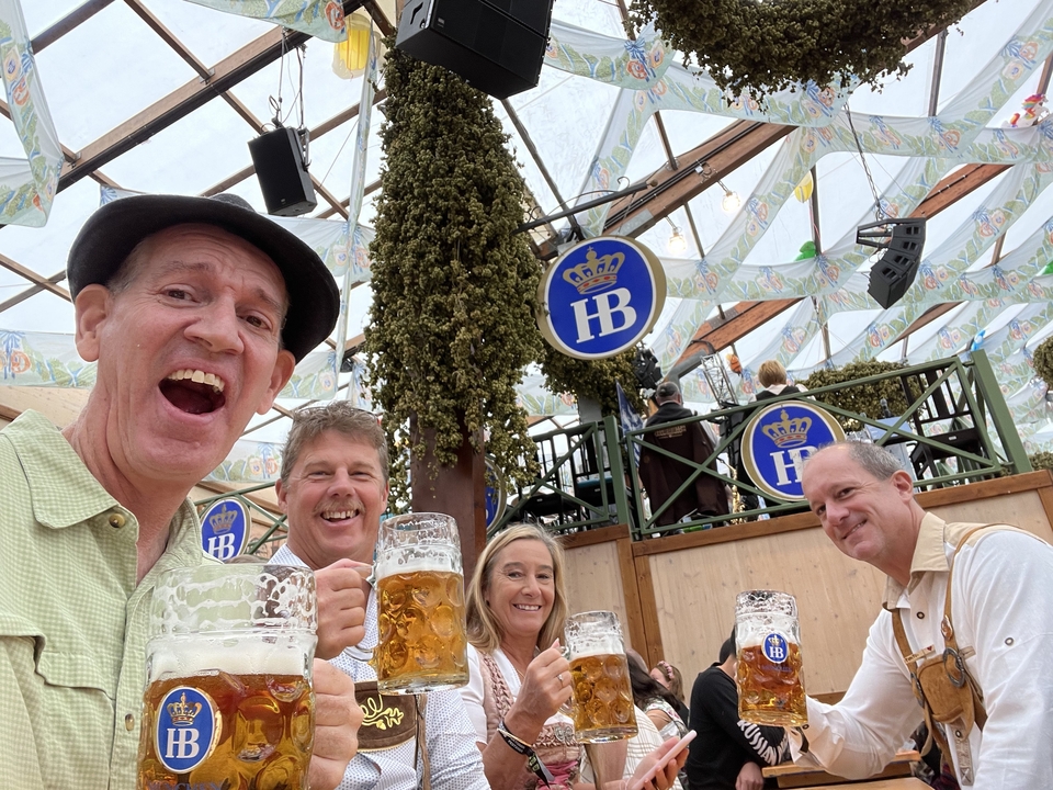 Des gens qui savourent de la bière sous une tente de festival avec des enseignes HB.