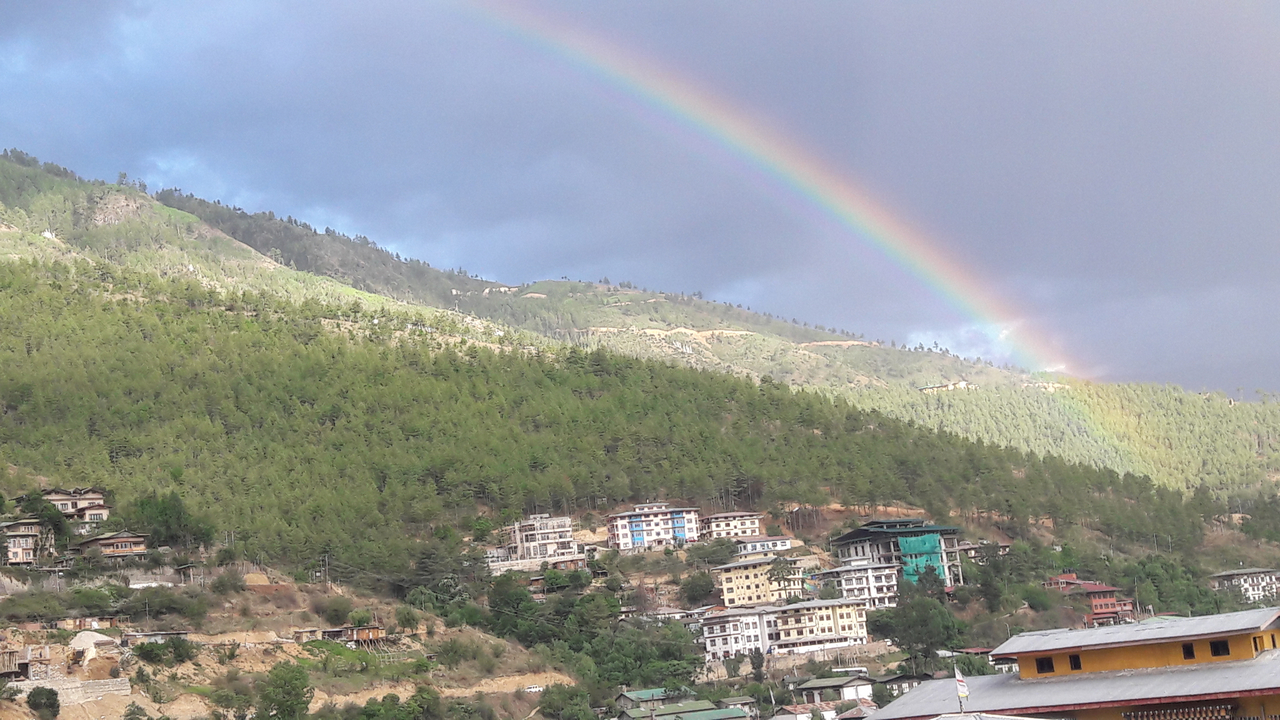 Arc-en-ciel au-dessus d'une ville nichée contre une montagne.