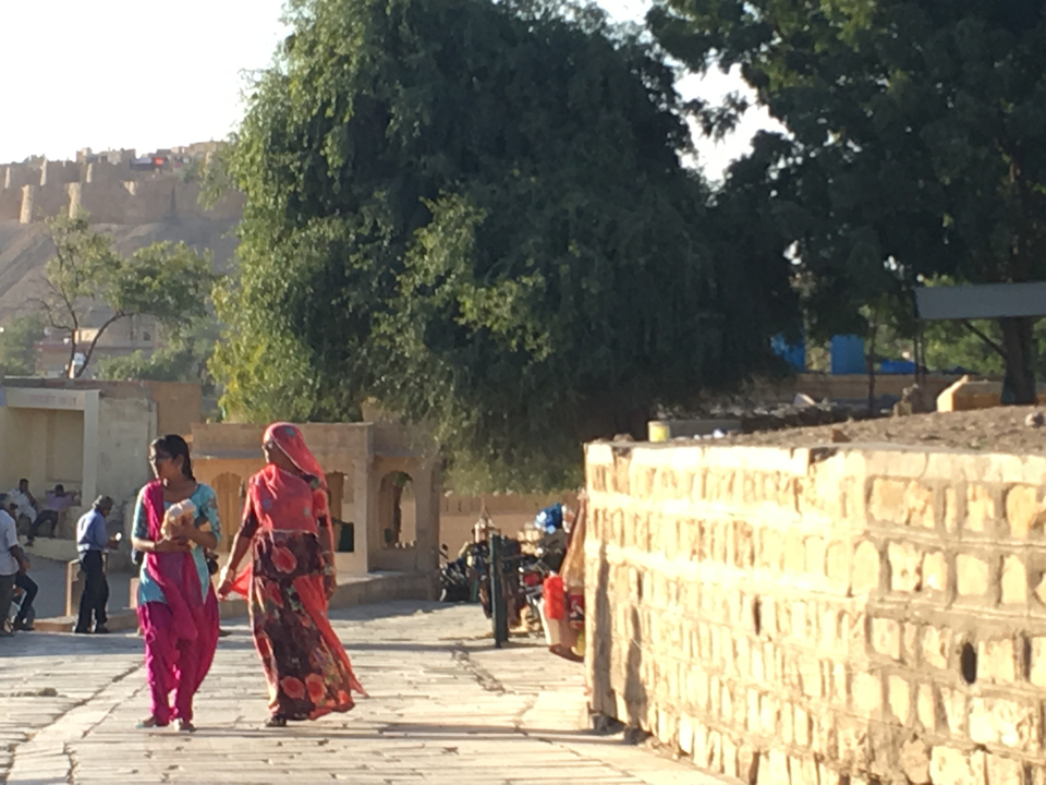 Des femmes en tenue traditionnelle marchant dans la rue.
