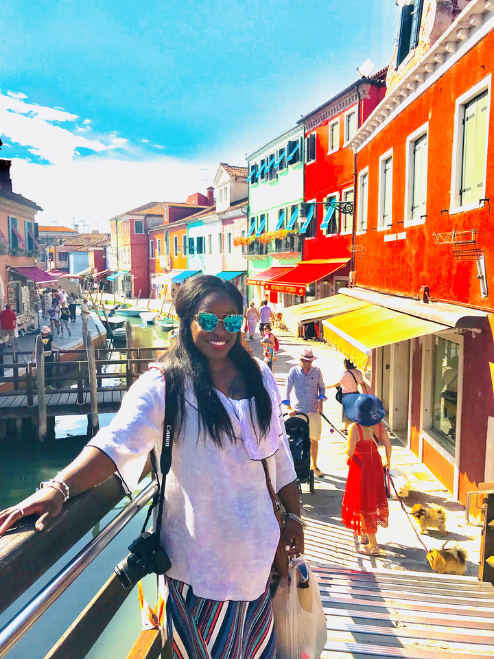 Personne posant dans une rue colorée avec des canaux